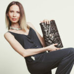 Elegant fashionable woman with leather handbag. Stylish girl holding black bag. Women fashion vogue. Studio.